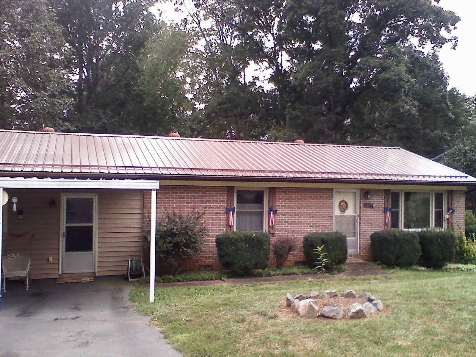 Bronze metal roof and carport on a brick ranch home — Roof Repair work by our crew in Wales