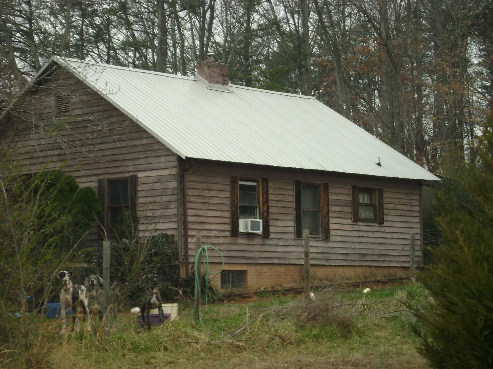 White metal roof on an old wood sided farmhouse, from a Metal Roof Installation job in Wales